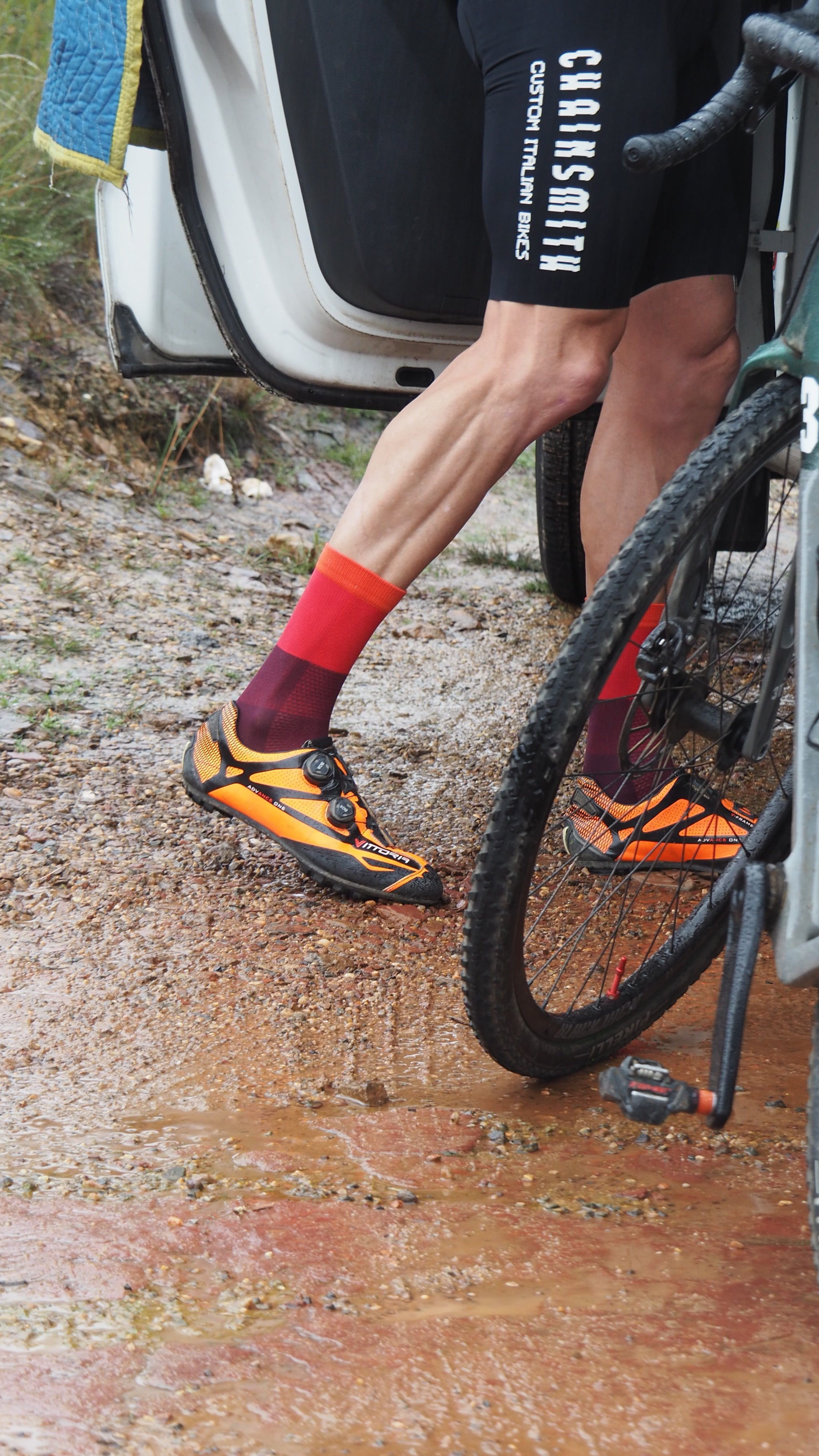 Cyclist preparing for a gravel ride wearing Chainsmith red socks