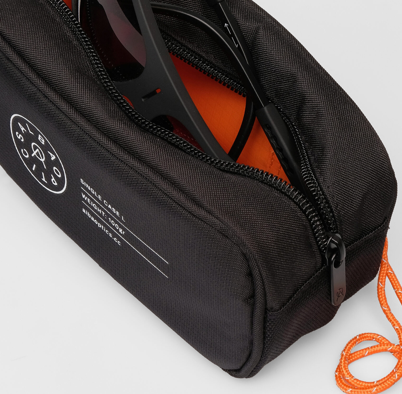 Interior of Alba Optics Single Case L showing mesh pocket and AirTag holder for secure sunglasses